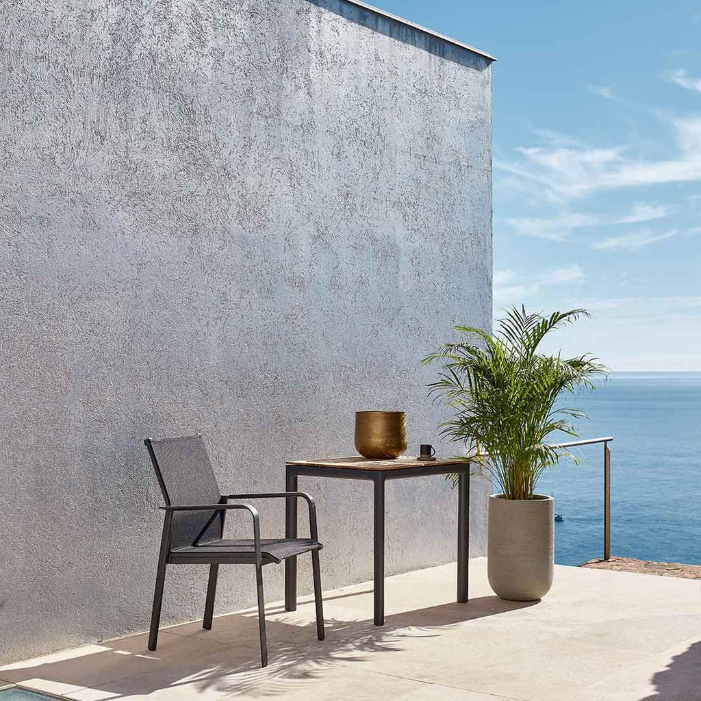 Stabelstol ute Breeze aluminium/textilen 58x65 cm sett fra siden på balkong