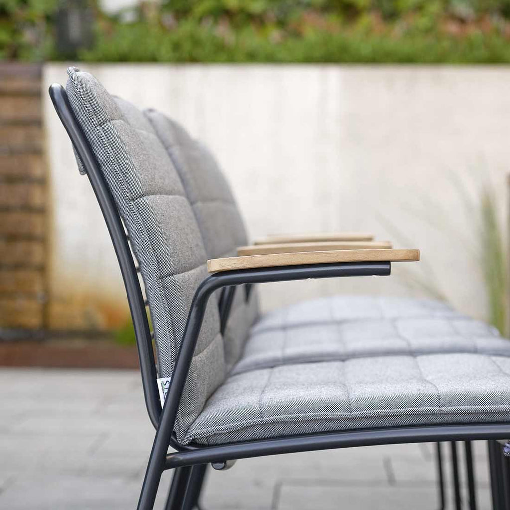 Montert Stabelstol ute Levi rustfritt stål med teak armlener Stern på terrasse